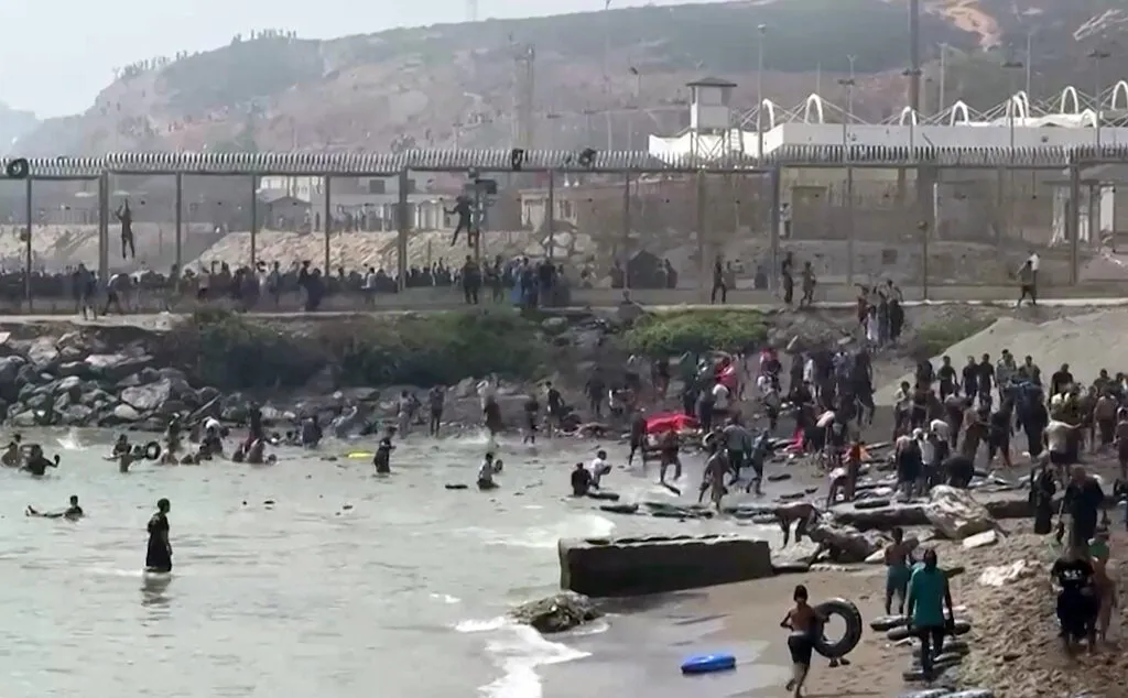 A frame grab from an AFP video showing migrants reaching the shore of Ceuta after swimming around the border fence between Morocco and Spain on July 30, 2026.
